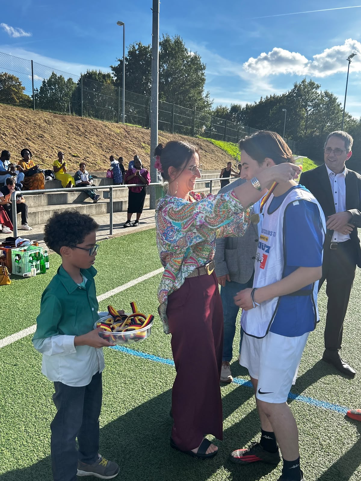 Frau Alina Götsch überreicht die goldene Medaille and die Siegerspieler